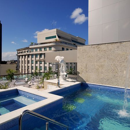 Hotel Atlantico Business Centro Rio de Janeiro Exterior foto The photo shows a rooftop area featuring a swimming pool and a spa. The pool is inviting with a clear blue water, and there appears to be a waterfall feature. Surrounding the pool are areas for relaxation, possibly with sun loungers. In the backgroun